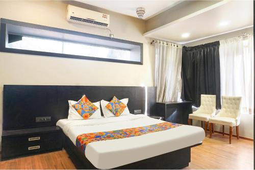a bedroom with a bed and two chairs and a window at Hotel Star Light - Near Jagtap dairy in Pune