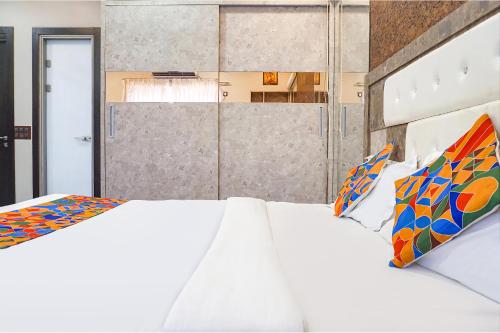 a bedroom with two white beds with colorful pillows at Hotel Star Light - Near Jagtap dairy in Pune