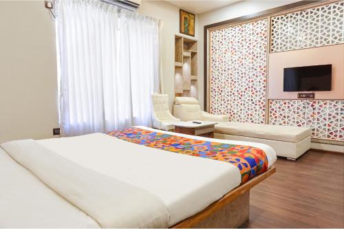 a bedroom with a bed and a couch and a tv at Hotel Star Light - Near Jagtap dairy in Pune