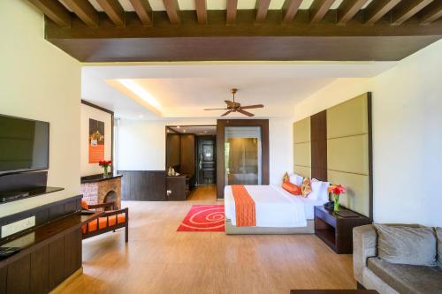 a bedroom with a bed and a flat screen tv at Sinclairs Retreat Kalimpong in Kalimpong