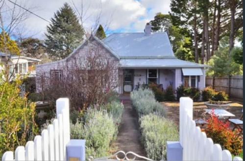 a white picket fence in front of a house at Chinoiserie - Blue Mountains Boho Luxe in Katoomba