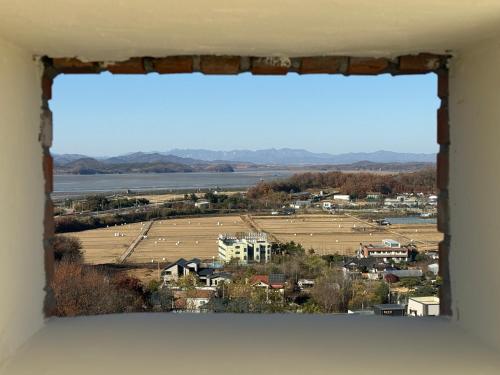 a view from a window of a town with a field at DMZ Hotel & Tour Guide in Paju
