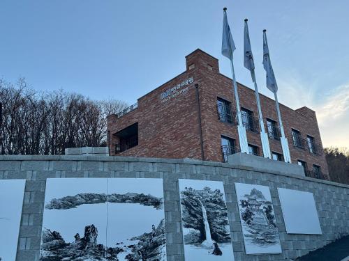 a brick building with flags on top of it at DMZ Hotel & Tour Guide in Paju