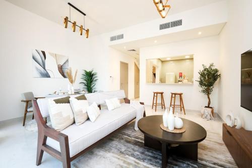 Una sala de estar con un sofá blanco y una mesa. en Luxury Villa in Marbella RAK, en Ras al Khaimah