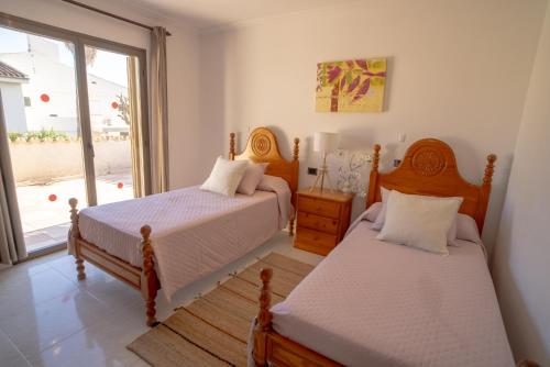 a bedroom with two beds and a window at Beach House Llenaire in El Port