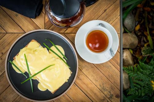 a table with a plate of food and a cup of tea at Sunbirds Oasis Lodge in Hoedspruit
