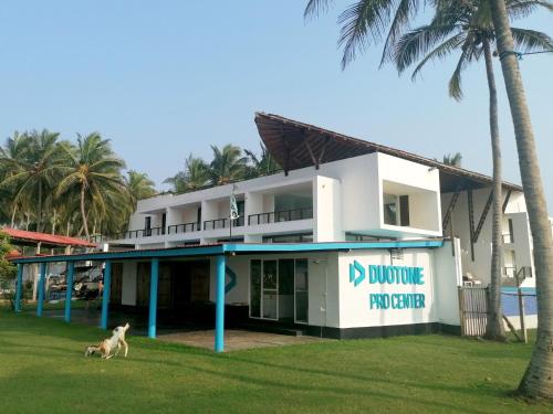 a dog running in front of a building at Kitekuda Kite Resort in Vannativillu
