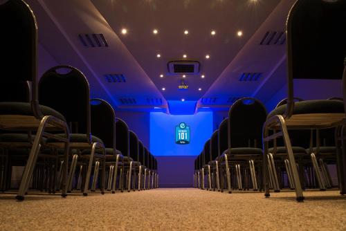 an empty cinema room with chairs and a stage at Hotel Estação 101 - Itajaí in Itajaí