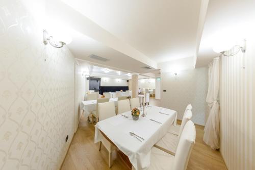 a white dining room with a white table and chairs at Hotel Studio in Veliko Tŭrnovo