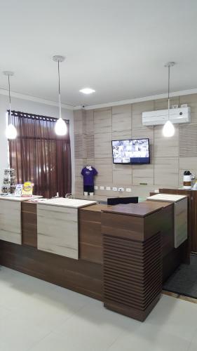 a lobby with a counter with a tv in it at Hotel Trevita Foz in Foz do Iguaçu