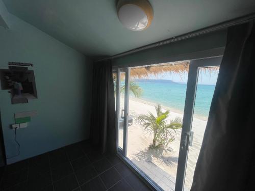 a room with a balcony with a view of the beach at WHITE SAND ARK RESORT in Koh Rong Island