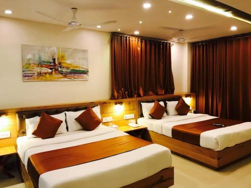 a hotel room with two beds and curtains at Grandeur By Avion Palace Near T2 International Airport in Mumbai