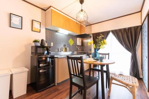 a small kitchen with a table and a microwave at Route99 Yumoto 箱根湯本駅近山沿い川沿い 箱根湯本徒歩8分WIFI 大人気ゲーム機無料 最大6名 無料駐車場 in Hakone