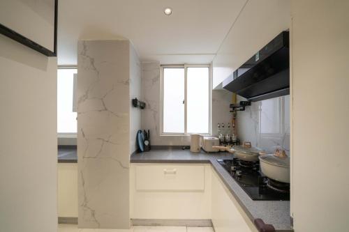 a kitchen with white cabinets and a sink and a window at Book and Bed-People's Square in Shanghai