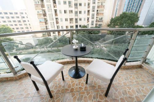 a balcony with a table and two chairs on a balcony at Book and Bed-People's Square in Shanghai