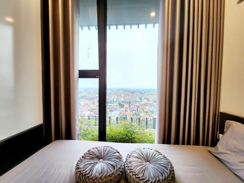 una camera da letto con un letto con una grande finestra di Thỏ's homestay -căn hộ 2n2wc khu Onsen, khu Căn hộ cao cấp nhất tại Ecopark Hưng Yên a Kim Quan