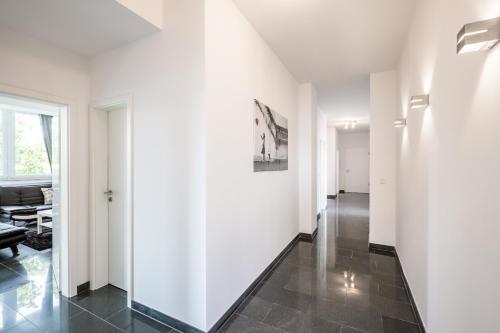 a hallway with white walls and a black tile floor at Work & stay Langenfeld in Langenfeld