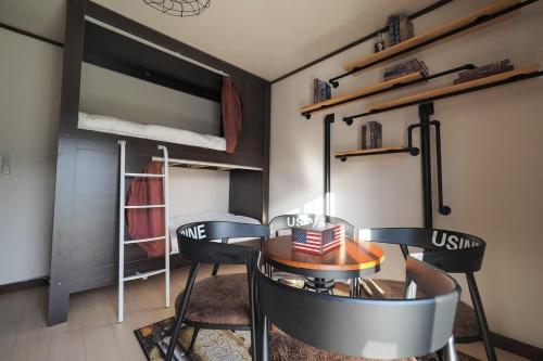a room with a table and two chairs and a bunk bed at 【芦ノ湖徒歩10分＆バス停1分】一棟貸切最大14人 大人數BBQ可能 パーティ 『ROUTE99』 in Moto-hakone