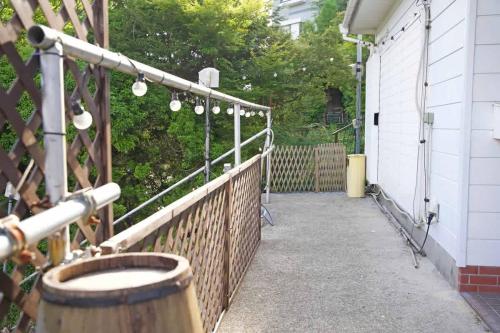 a porch of a house with a fence and lights at 【芦ノ湖徒歩10分＆バス停1分】一棟貸切最大14人 大人數BBQ可能 パーティ 『ROUTE99』 in Moto-hakone