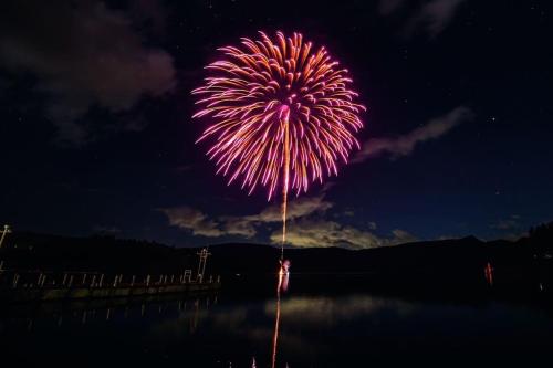 a firework display in the sky over a body of water at 【芦ノ湖徒歩10分＆バス停1分】一棟貸切最大14人 大人數BBQ可能 パーティ 『ROUTE99』 in Moto-hakone