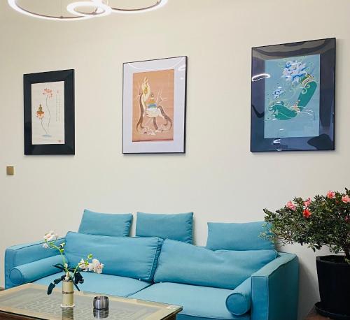 a blue couch in a living room with pictures on the wall at Fuxian Lake Qishe B&B in Chengjiang