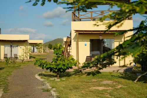 a building with a tree in front of it at Tres Velas Surf in Celestino Gasca