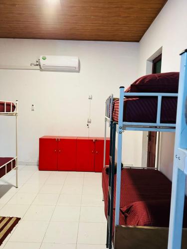a room with two bunk beds and red cabinets at Rock View Hostel Ella in Ella