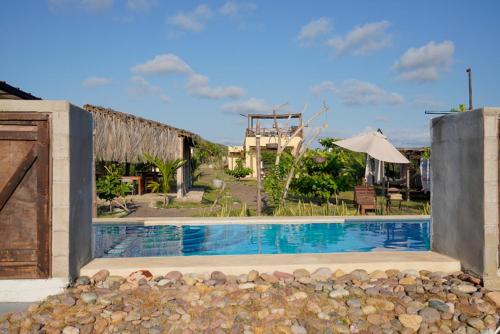 a swimming pool in front of a house at Tres Velas Surf in Celestino Gasca