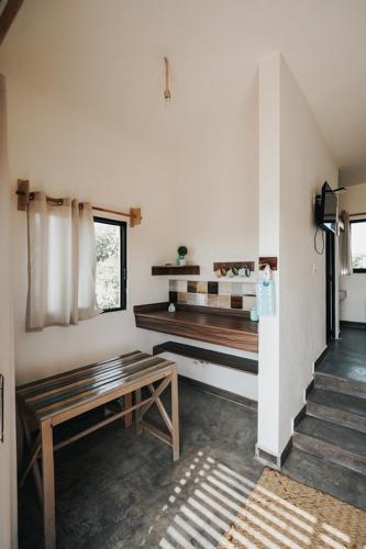 a living room with a bench and a table at Tres Velas Surf in Celestino Gasca