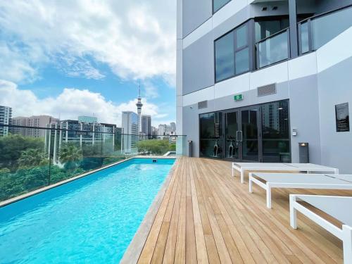 a swimming pool with a view of a building at Luxury Design Parkside Living in CBD vs Aircon in Auckland