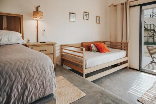 a bedroom with a bed and a chair and a window at Tres Velas Surf in Celestino Gasca