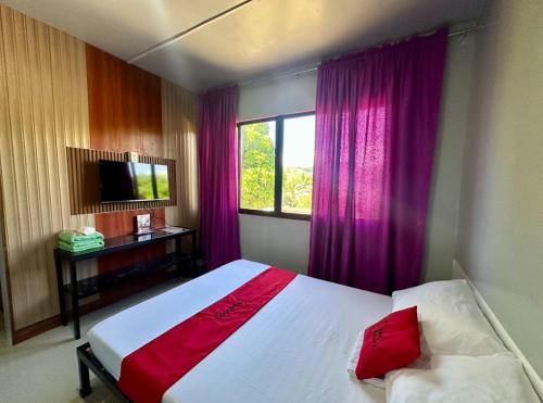una camera da letto con un letto e una finestra con tende viola di RedDoorz at FJ Hotel Tubungan Iloilo a Tubungan