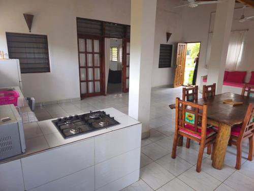 a kitchen with a stove and a table and a dining room at Malindi-Lovely Two Bed Room with swimming pool in Malindi