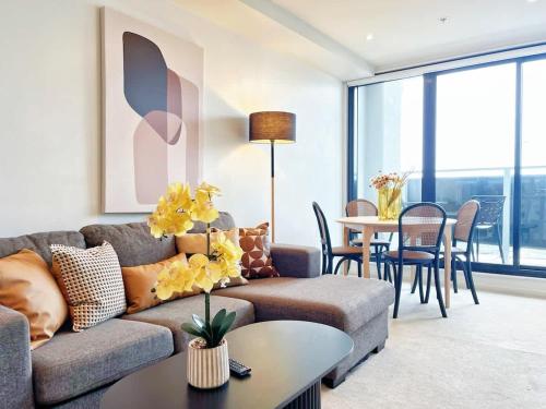 a living room with a couch and a table at The Heart of City Living with Incredible City & Skytower View Nearby Queen St in Auckland