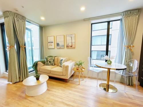 a living room with a couch and a table at Stylish Cozy Studio Nearby SkyTower-Pool Gym Sauna in Auckland