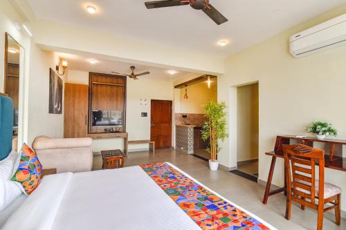 a bedroom with a bed and a desk and a kitchen at Jingle Tree Resort - Nr Arambol Beach in Pernem