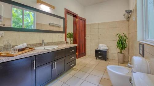 a bathroom with a sink and a toilet and a mirror at Terrazas del Caribe Hotel in Puerto Viejo