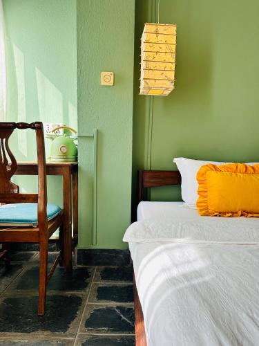a bedroom with a bed and a chair and a table at Hotel Darwin in Kathmandu