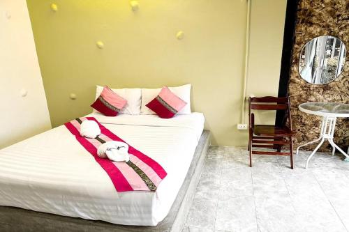 a bedroom with a bed with a towel on it at Pai Tawan Resort Hotel - Pet friendly in Khon Kaen