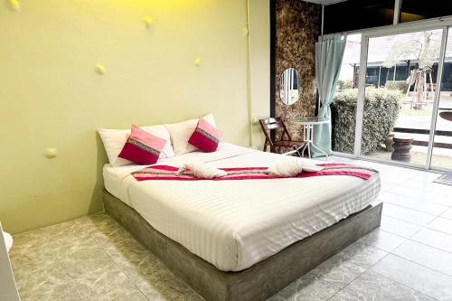 a bedroom with a bed with red and white pillows at Pai Tawan Resort Hotel - Pet friendly in Khon Kaen