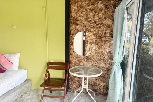 a room with a table and a mirror on a wall at Pai Tawan Resort Hotel - Pet friendly in Khon Kaen