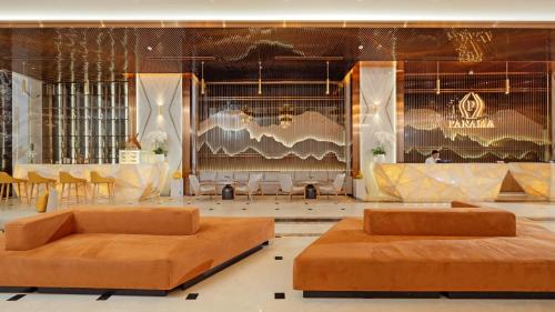 two brown beds in a room with tables and chairs at PANAMA Nha Trang Hotel in Nha Trang