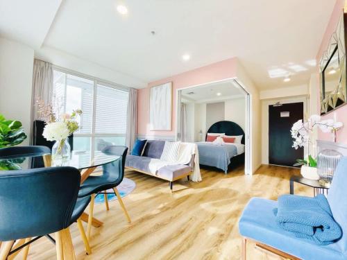 a living room with a table and a couch at Tasteful Luxury Modern 2BR with Aircon in the City Next to Albert Park in Auckland