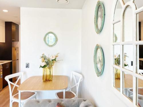 a dining room with a table and chairs and plates on the wall at Lime-Fresh Garden Atmosphere CBD 1B Pool Sauna Gym in Auckland