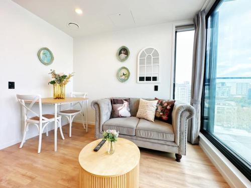 a living room with a couch and a table at Lime-Fresh Garden Atmosphere CBD 1B Pool Sauna Gym in Auckland