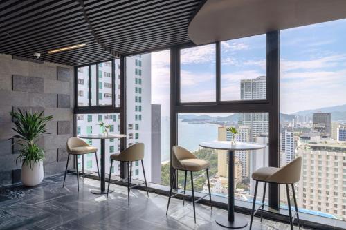 a room with tables and chairs and a view of the city at PANAMA Nha Trang Hotel in Nha Trang