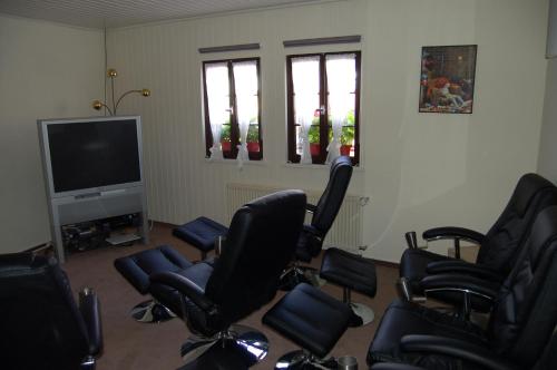 a room with chairs and a flat screen tv at Landgasthaus Pfahl in Wershofen