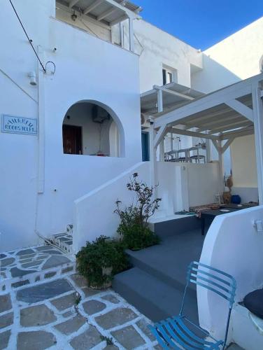a white house with stairs and a blue chair at Casa Filareti-Family studio in Ios Chora
