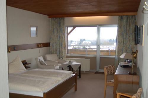 a bedroom with a bed and a couch and a window at Landgasthaus Pfahl in Wershofen