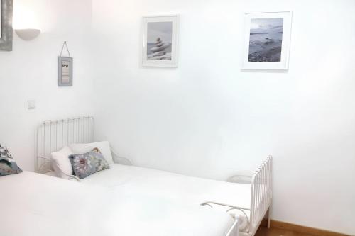 2 letti in una camera bianca con foto appese al muro di Charming House in Sintra + View a Sintra
